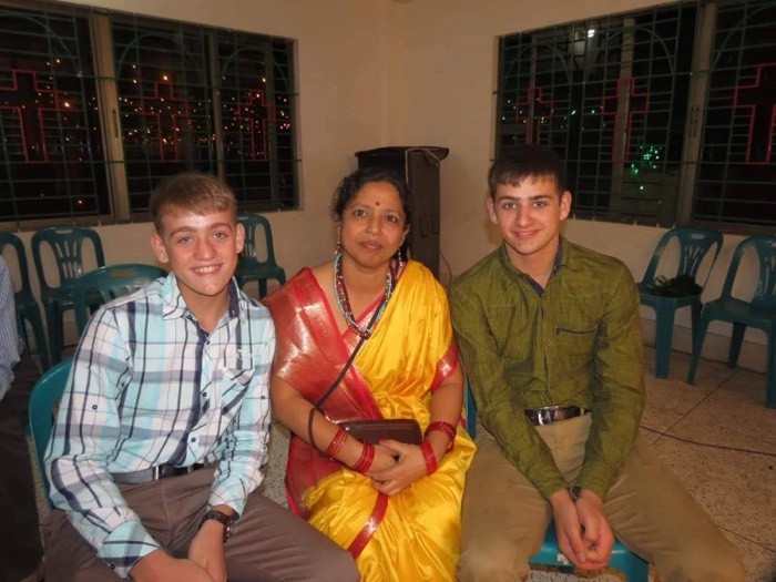 BLCC students and their teacher celebrating together in traditional dress at night