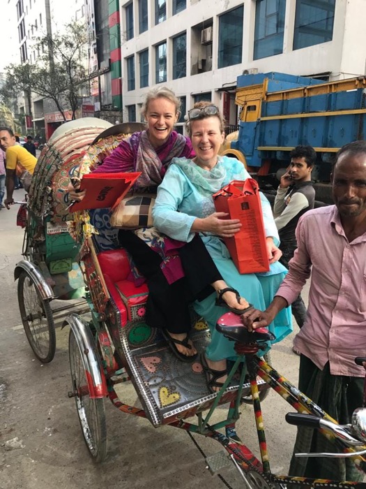 Two BLCC students laughing together on a rickshaw ride through Dhaka