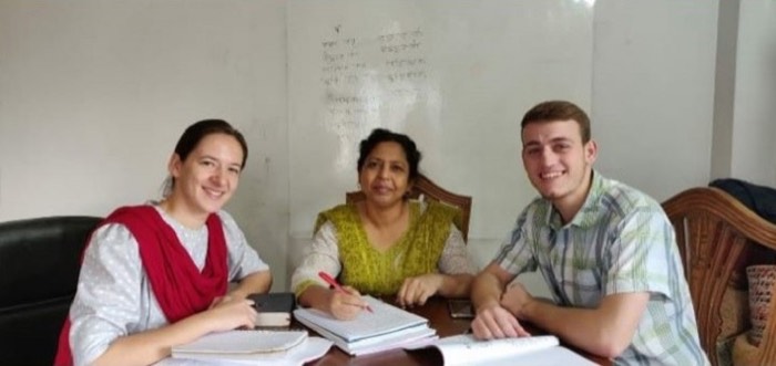 Two BLCC students studying Bangla with their teacher